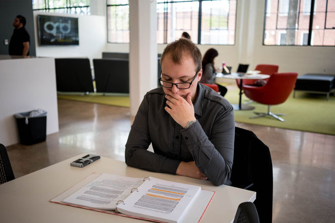 man reading a binder at a table