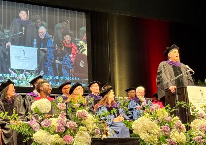Person speaking at podium during graduation ceremony