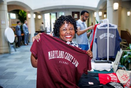 Alicia Wilson holding up a Maryland Carey Law T-shirt